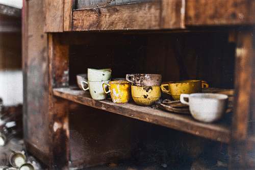 coffee cup assorted-color teacups on brown wooden shelf pottery